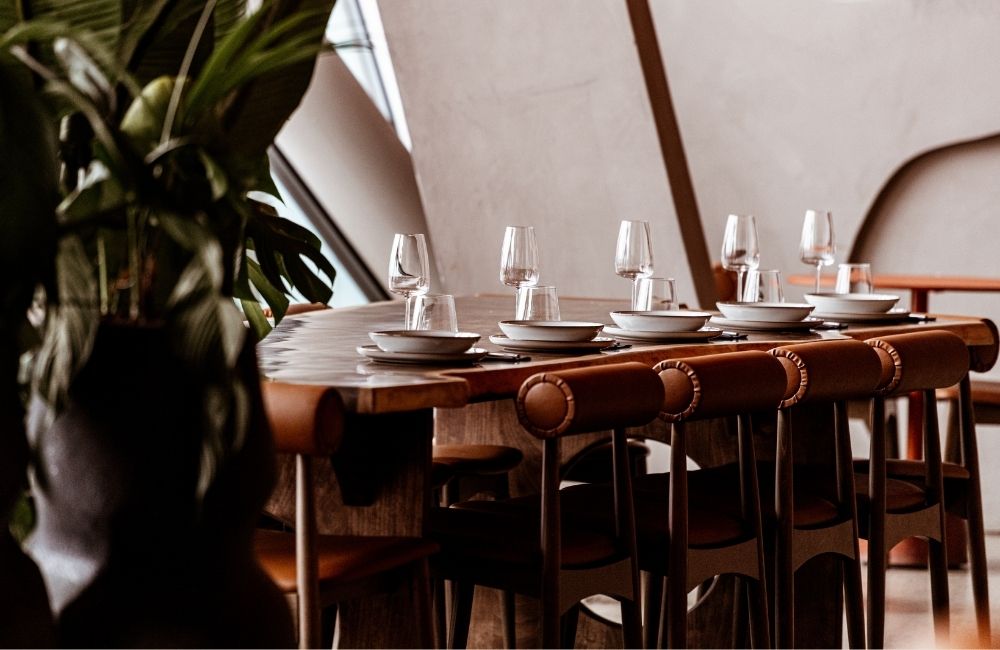 Modern stílusban megterített hosszú étkezőasztal egy prémium éttermi rendezvényhelyszínen. BOHO Bar Budapest