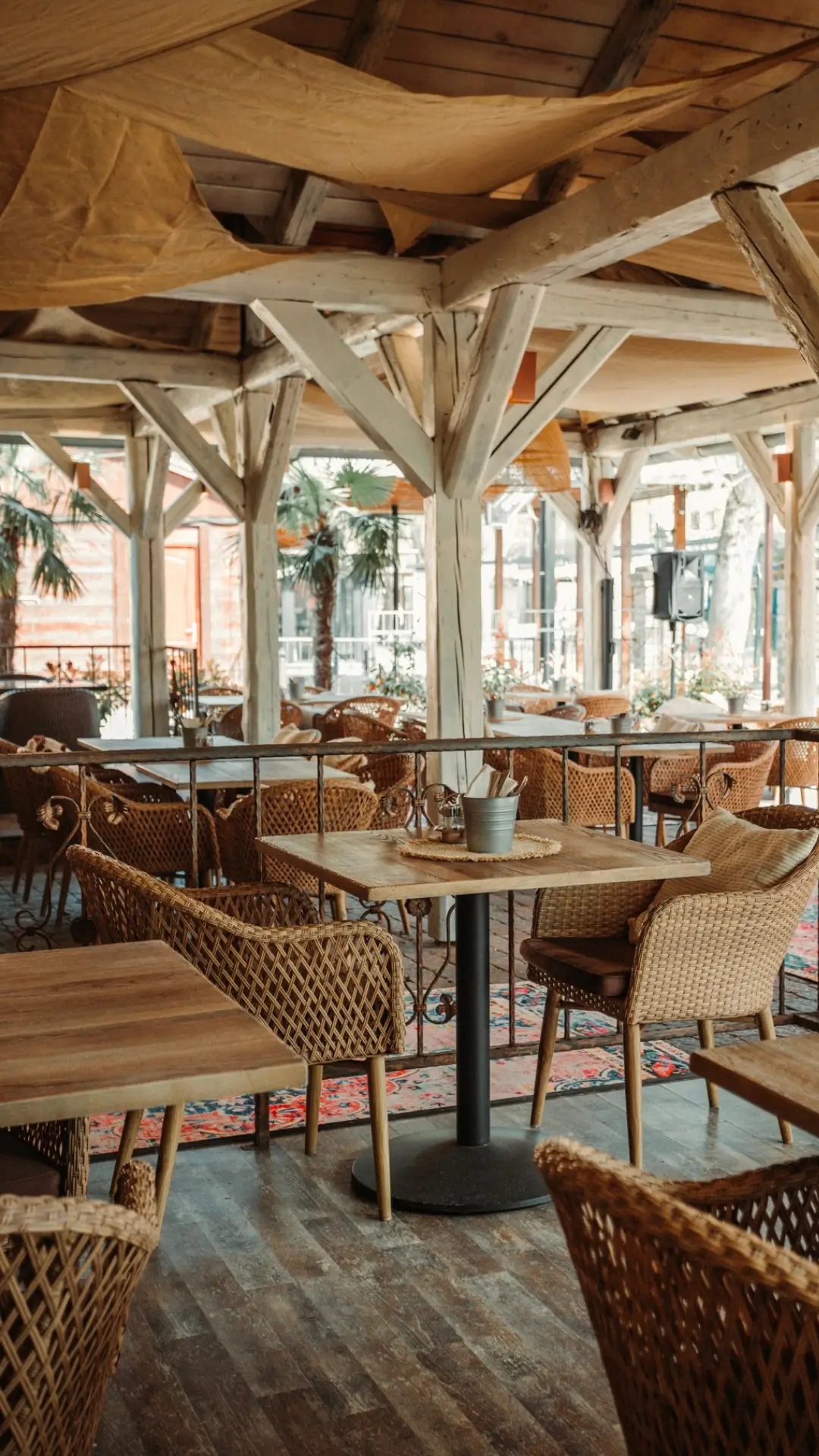 Hangulatos, fedett éttermi terasz fonott székekkel a siófoki La Riva Hotelben – kényelmes helyszín szabadtéri rendezvényekhez.