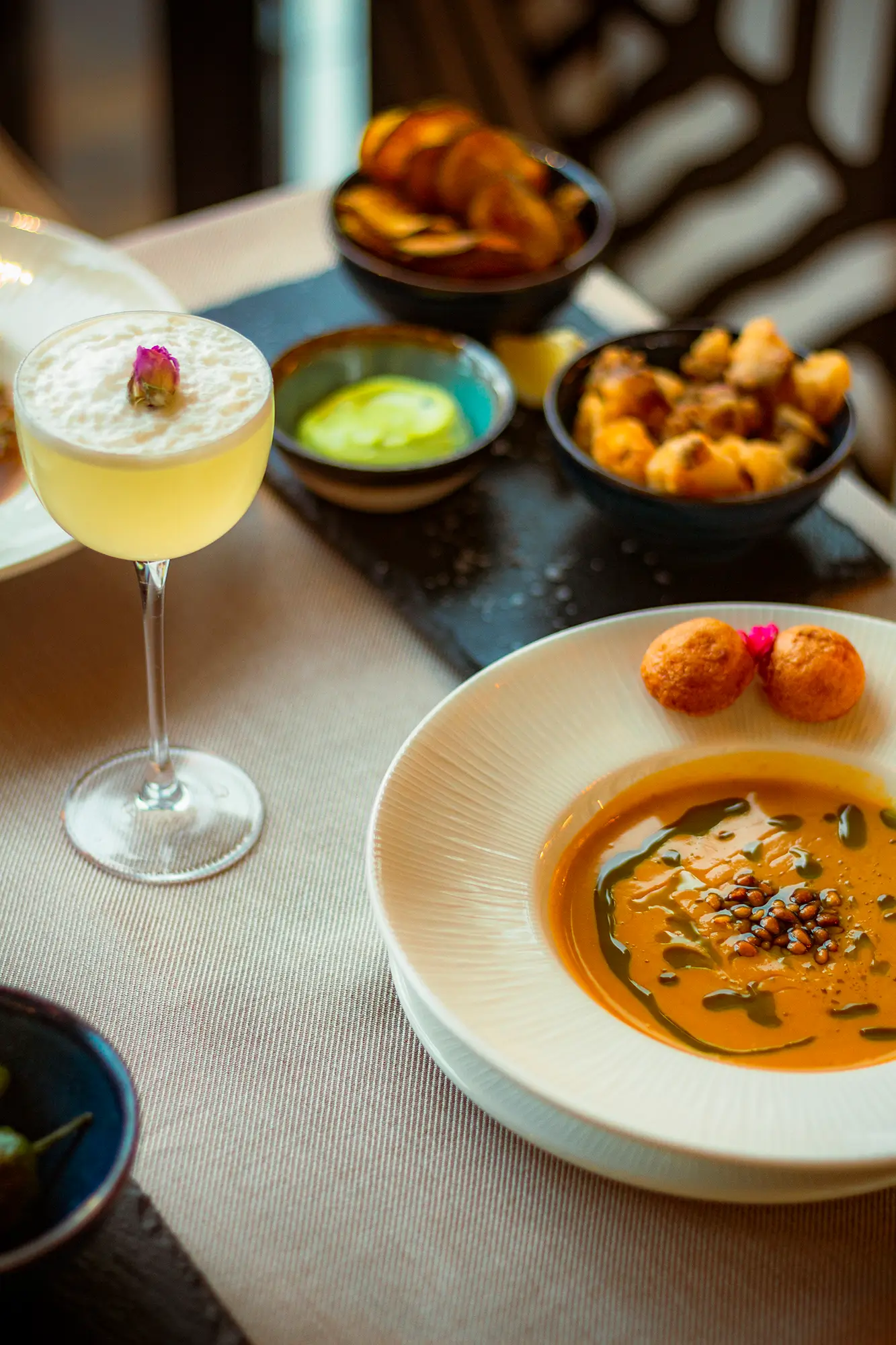 Elegáns koktélok és gourmet bárfalatok egy hangulatos rendezvényhelyszín asztalán. Selva Skybar x Aston Martin Budapest