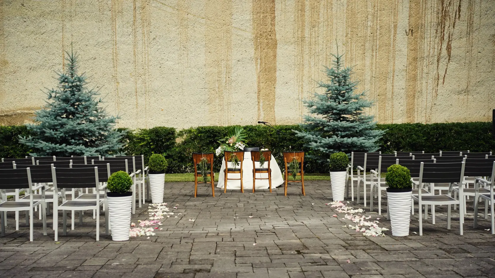 Kültéri esküvői szertartás helyszín székekkel és virágdíszítéssel a Bolyki Szőlőbirtok csendes udvarán